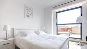 A bedroom with a bed, bedside tables, a lamp, a window, and a view of the outside. - Peaceful  Windows of Jerusalem (Jerusalem)