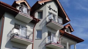 A multi-story building with balconies and a children's play area with toys and a slide. - Guest House Vipabo (Rewal)