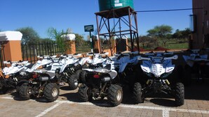 Ein Parkplatz mit mehreren nebeneinander abgestellten Quads.