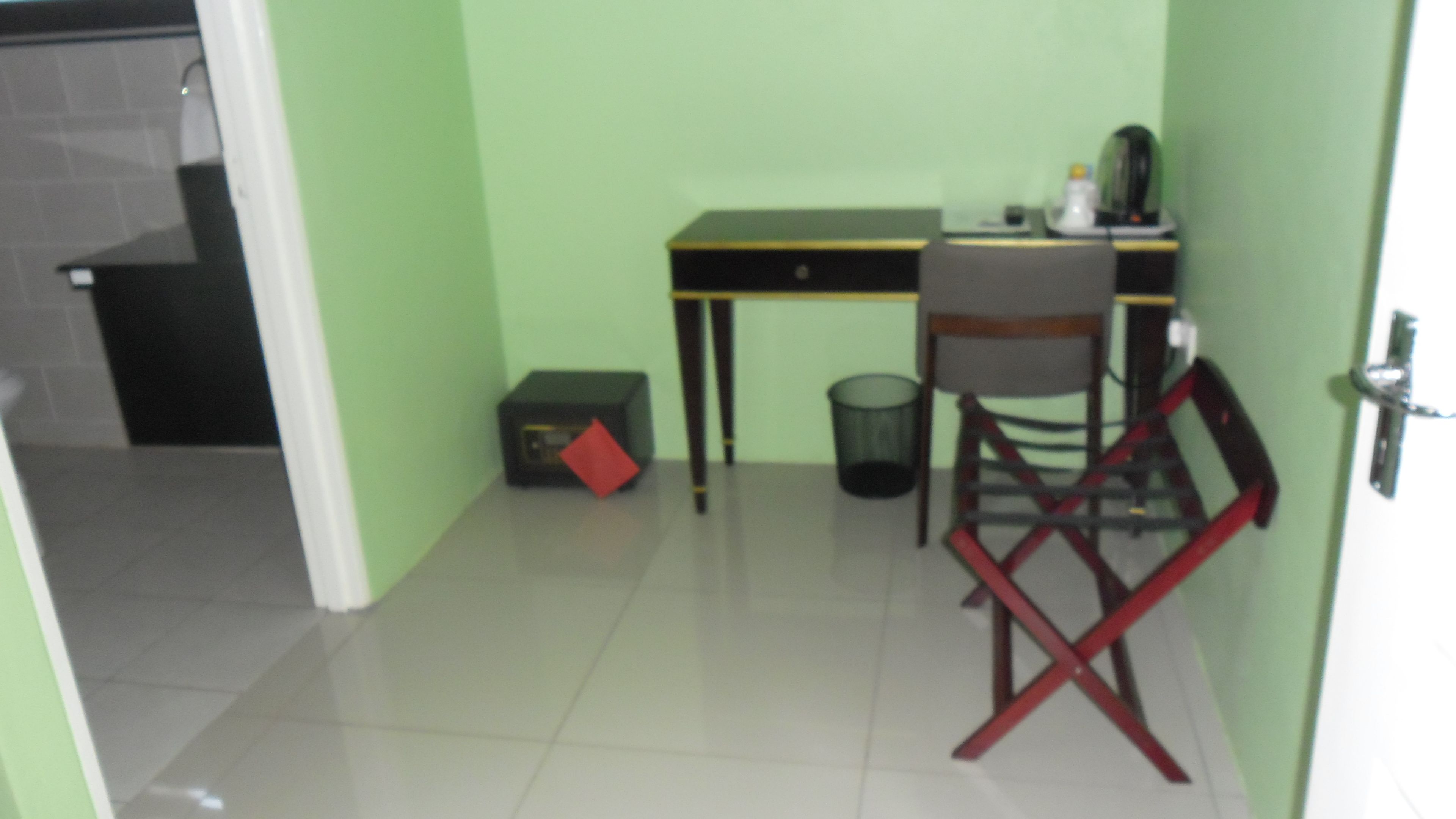 Ein kleines Zimmer mit Schreibtisch, Stuhl und Mülleimer.