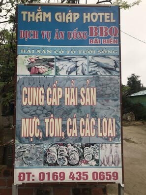 Schild des Thanh Giap Hotels, das gegrillte Speisen und Meeresfrüchte anwirbt.