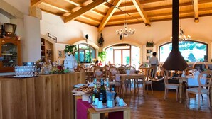 A restaurant with wooden interiors, a bar area, and a view of the outdoors. - Guest House Terra di Venera (Acireale)