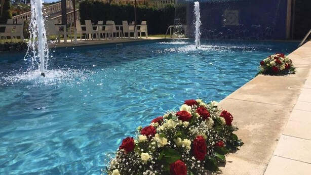 A pool with two water features and a flower arrangement. - Guest House Terra di Venera (Acireale)