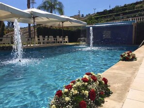 A pool with two water features and a flower arrangement. - Guest House Terra di Venera (Acireale)