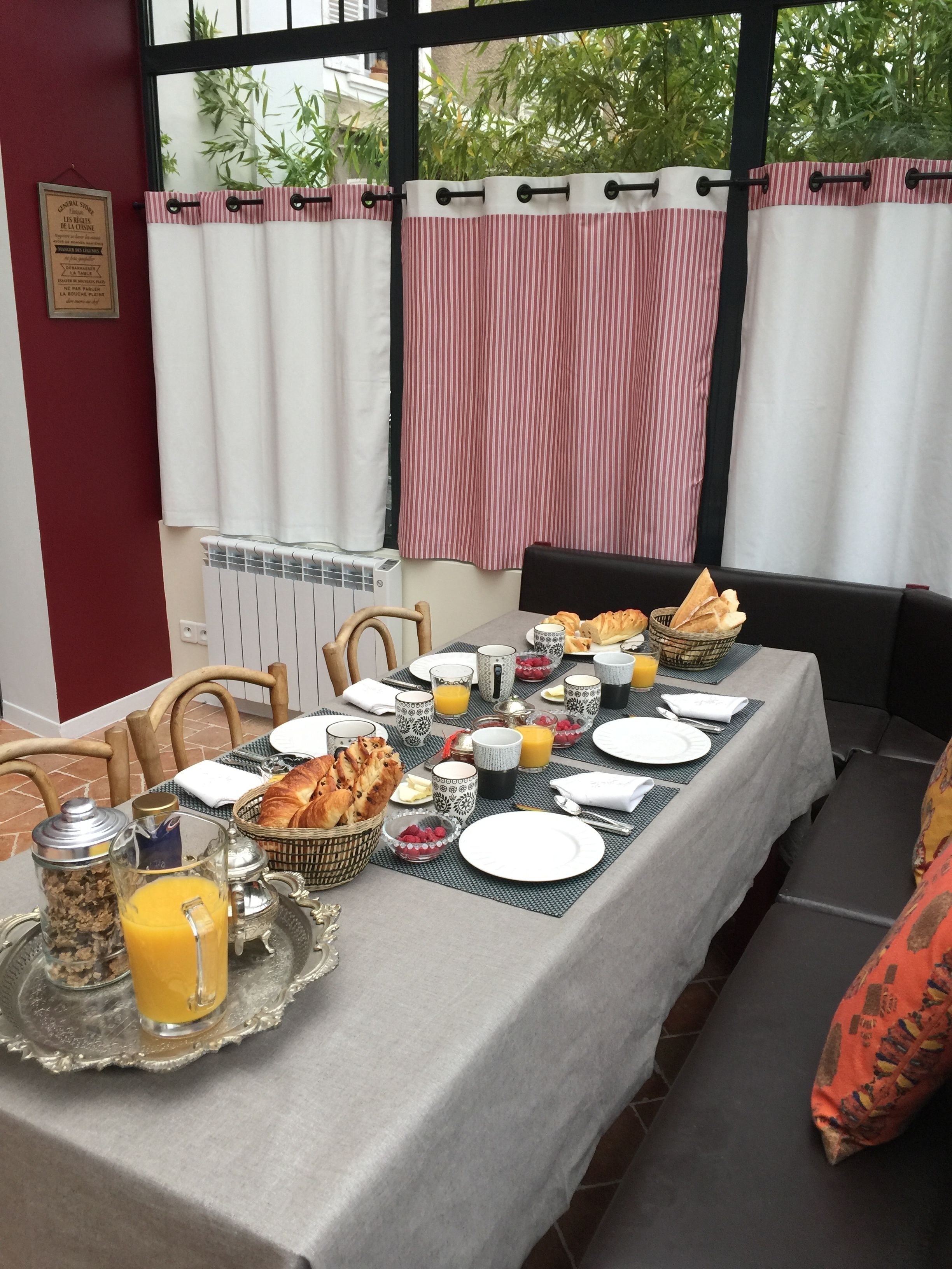 Une table de petit-déjeuner dressée avec des assiettes, des verres et une variété d’aliments pour le petit-déjeuner.