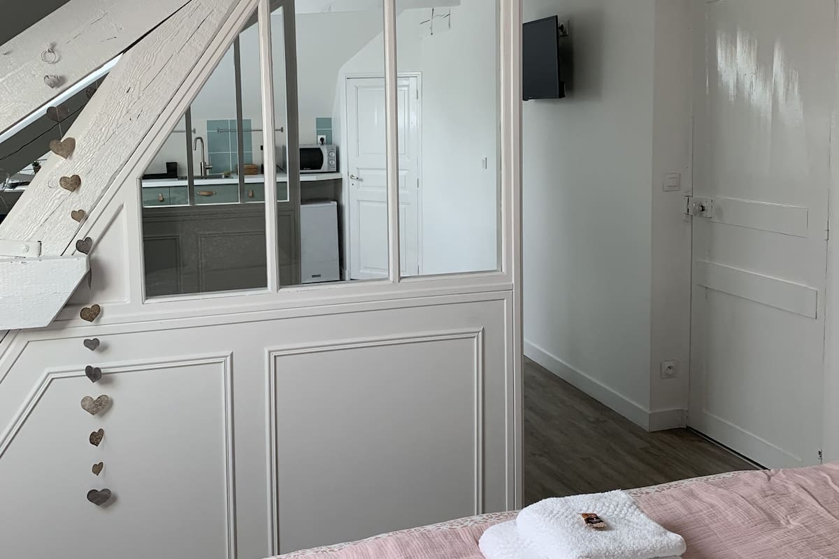 Un dormitorio con una cama, una escalera y vistas a la cocina.