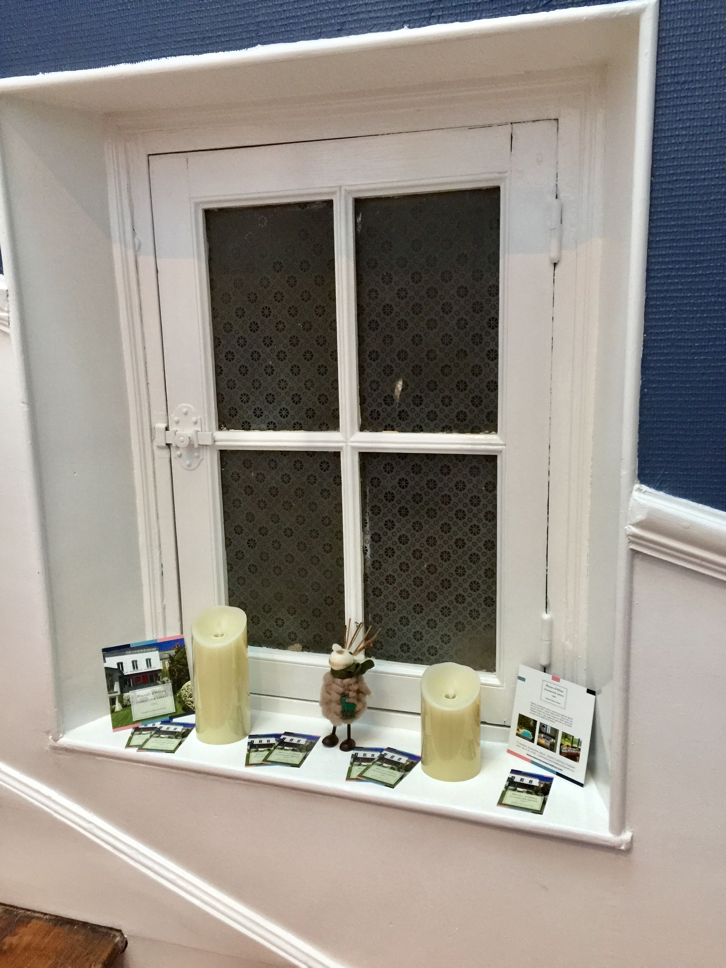 A window with a white frame and a decorative window ledge.