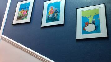 Three framed artworks on a blue wall.