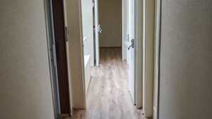 A hallway with wooden flooring, beige walls, and a ceiling light fixture. - Pelit Boutique Hotel (Adalar)