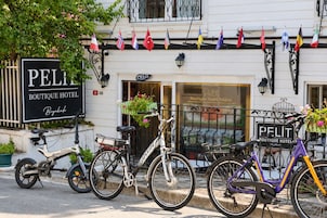 A boutique hotel named 'PELIT' with bicycles parked in front and flags hanging above the entrance.