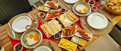 Una tavola imbandita con diversi prodotti per la colazione, tra cui uova, formaggio e pane.