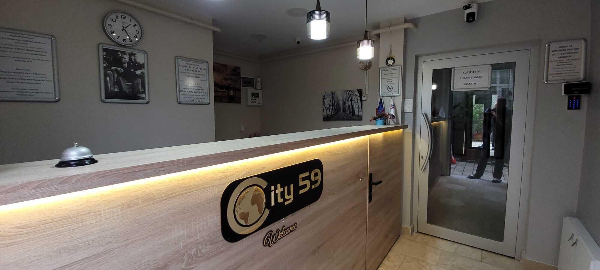 A reception desk with a sign reading "City 59 Welcome".
