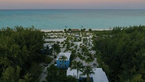 A beach view with a house surrounded by trees and a clear sky. - Andros Beach Club (Rolle Town)