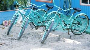 A turquoise bicycle parked in front of a blue building with a sign reading "Diving." - Andros Beach Club (Rolle Town)