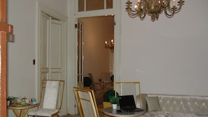 A living room with a sofa, two chairs, a coffee table, and a laptop. - Hotel Velvet 1928 (Cairo)