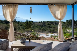 Un espace extérieur aménagé avec des sièges et offrant une vue sur un paysage montagneux.
