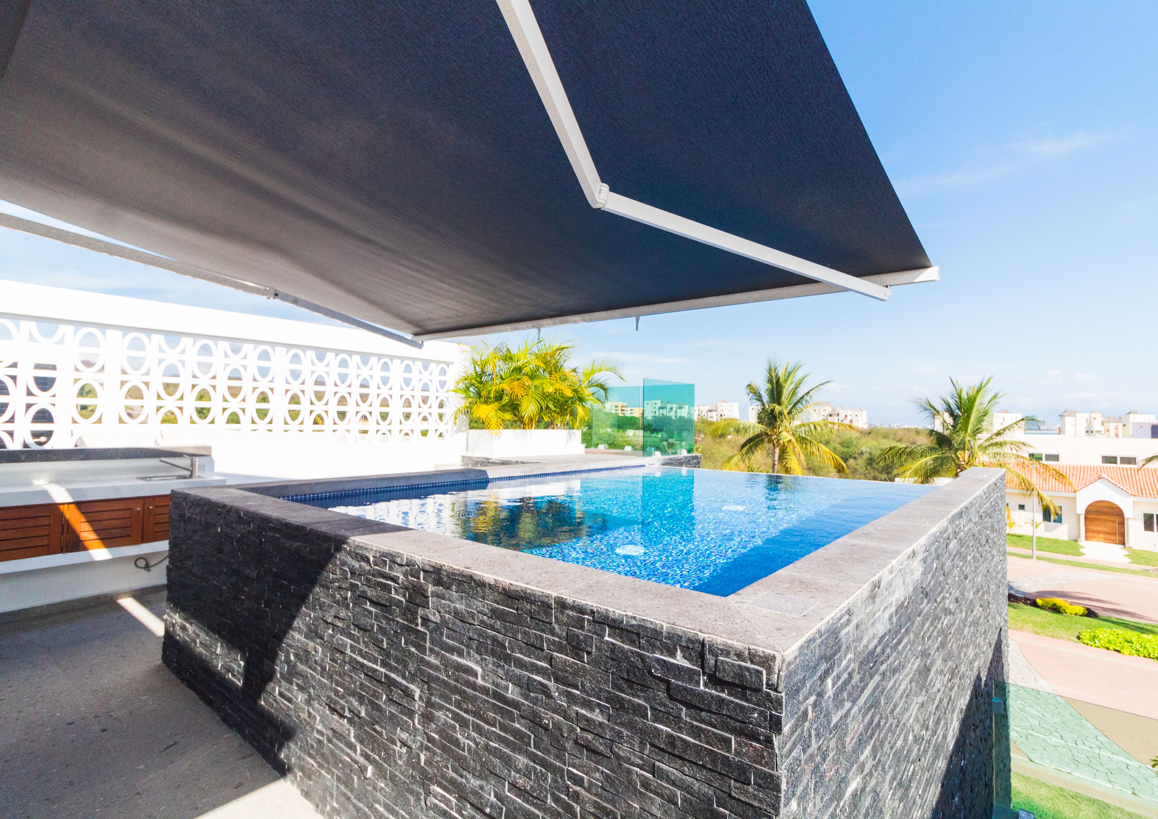 Alberca al aire libre, sombrillas en la alberca y camastros 