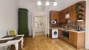 Una cucina funzionale con mobili in legno, lavatrice, forno a microonde e lavello.