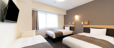 A hotel room with three beds, a flat-screen TV, a window with curtains, and a wall-mounted light fixture.