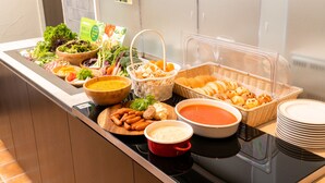 Un bufé con diferentes opciones de comida, como ensaladas, sopas y pan.