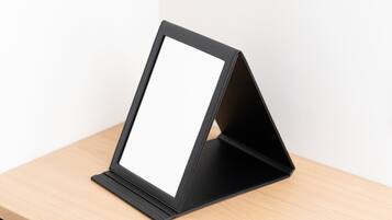 Un atril plegable negro sobre una superficie de madera.
