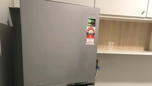 A compact kitchen with a stainless steel refrigerator, a washing machine, and a small round table. - Centrestage - Heart of Petaling Jaya 1 (Petaling Jaya)
