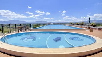 A rooftop swimming pool with a clear view of mountains in the background.