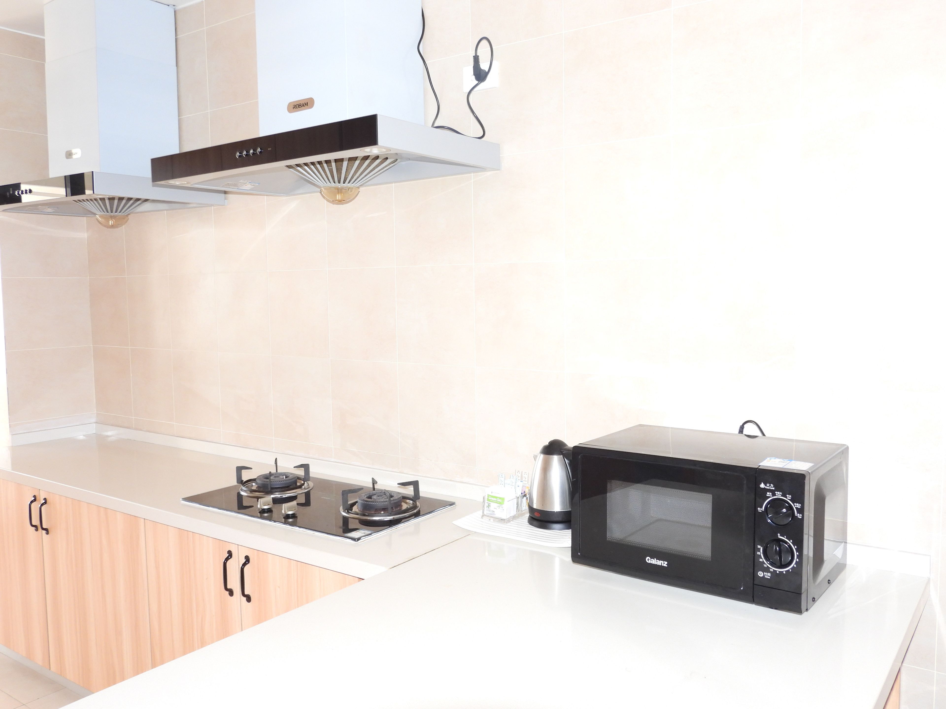 A kitchen with a gas stove, a microwave, and wooden cabinets.