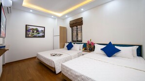 A hotel room with two beds, a window with a view, a painting on the wall, and a small table with a vase. - Hanoi Golden Hotel (Hanoi)