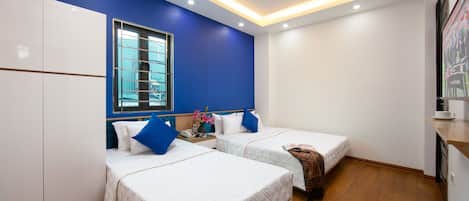 Une chambre d’hôtel avec deux lits, une fenêtre et une kitchenette.