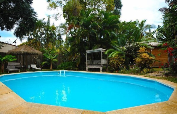 Alberca al aire libre, sombrillas en la alberca y camastros 