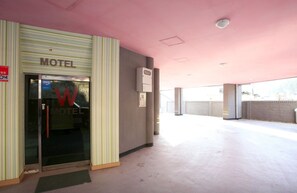 A motel with a striped exterior, a glass entrance, and a pink ceiling. - We Motel (Pyeongchang)