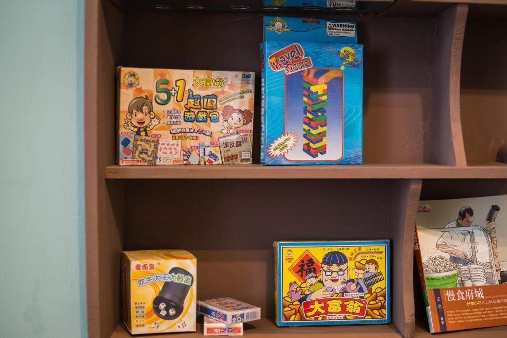 Una estantería con varios objetos empaquetados, entre ellos un juego de viaje, un rompecabezas y un aperitivo.