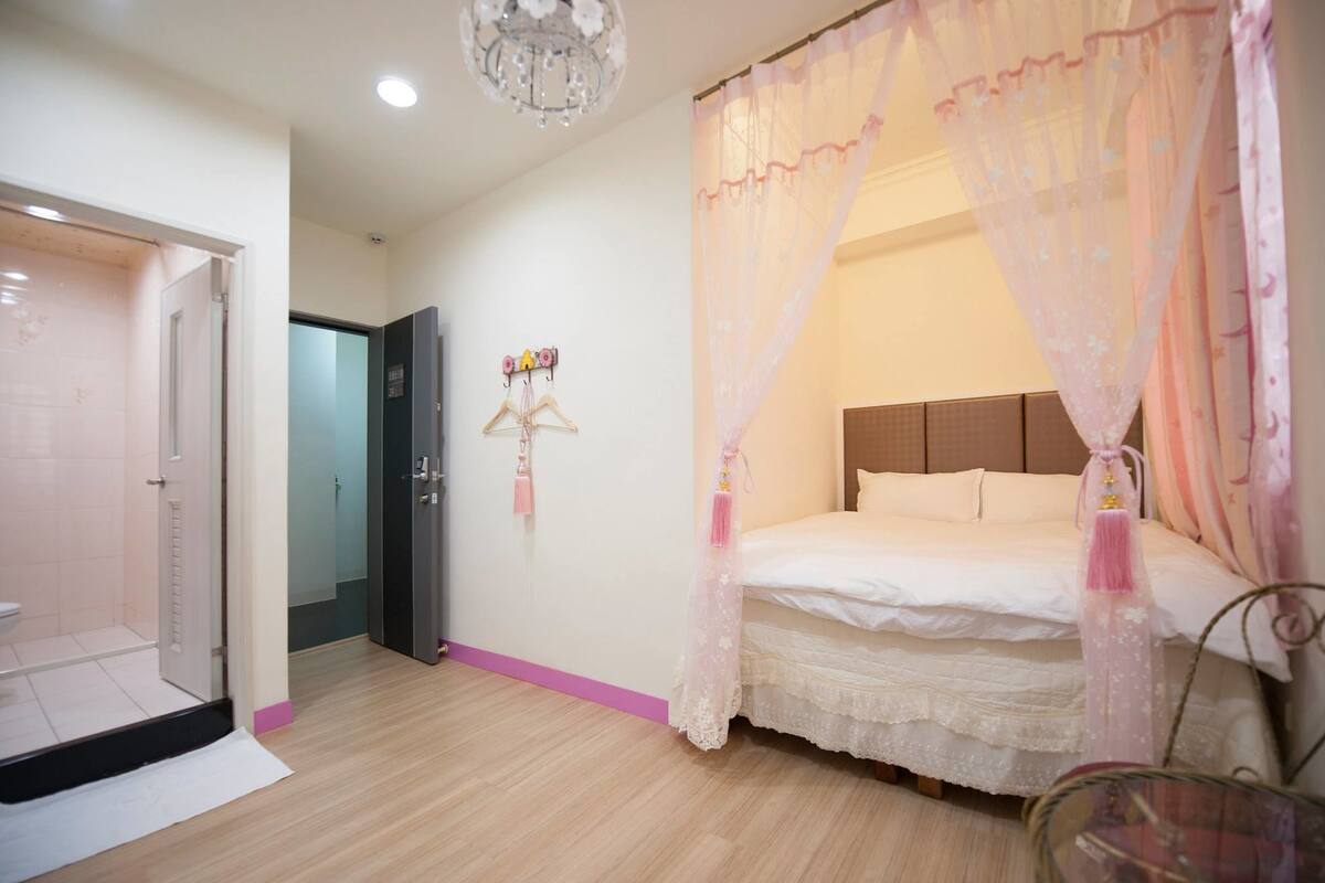Ein Schlafzimmer mit Bett, Baldachin, Tür und Wandhalterung.