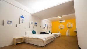 Una habitación de hotel moderna con piso de madera, una cama con ropa de cama blanca y una pared de acento amarillo brillante.
