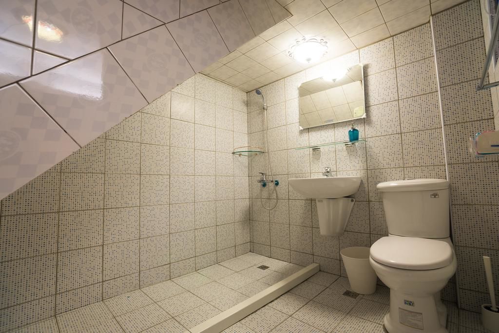 A bathroom with a shower, sink, and toilet.