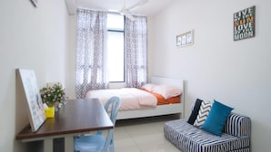 Un dormitorio con una cama, un escritorio, una silla, un sofá y un ventilador de techo.