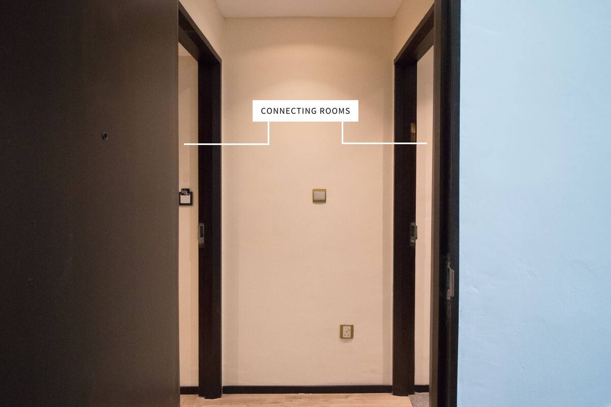 Un couloir avec deux portes portant l’inscription « PIÈCES COMMUNICATION » et un interrupteur sur le mur.