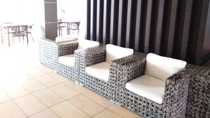 A seating area with patterned cushions and a tiled floor. - D'Esplanade City View Apartment (Johor Bahru)