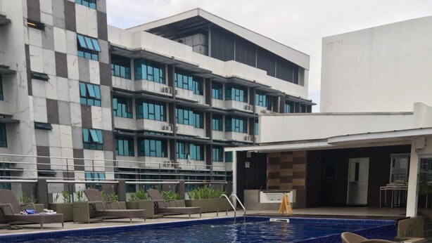 Zona de piscina en la azotea con sillones de descanso y una mesa de vidrio.
