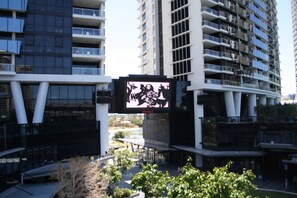 A modern building with multiple balconies and a large digital display. - Circle on Cavill - Private Apartments (Surfers Paradise)