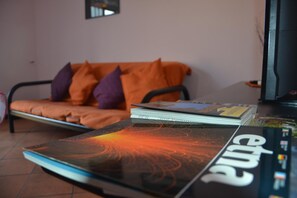 Una habitación con sofá, una mesita de centro y una revista.