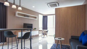 A modern living room with a sofa, a small round table, and a TV. - Pinnacle Studio - Heart of Petaling Jaya (Petaling Jaya)