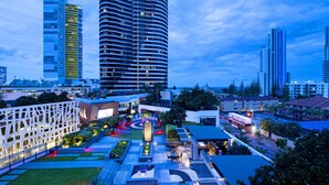 Un hotel moderno en el centro urbano, con un patio interior, edificios de gran altura y una combinación de construcciones residenciales y comerciales.