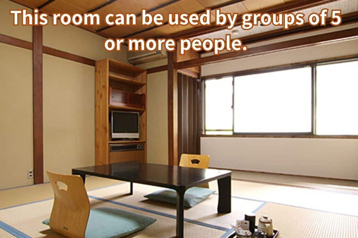 A tatami mat room with a low table and chairs, suitable for groups of 5 or more people.