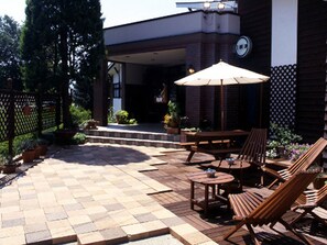 Relax in a shaded patio area with comfortable lounge chairs and a small table.