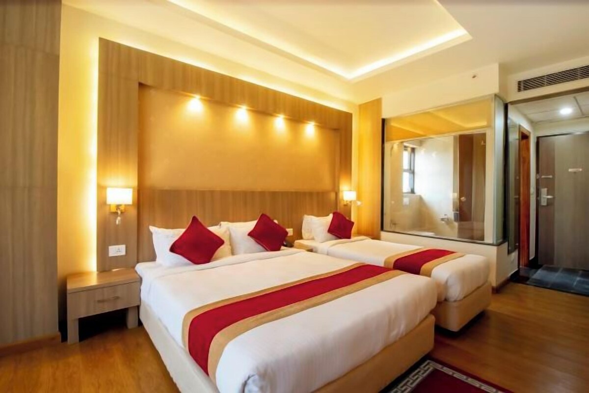 Een hotelkamer met twee bedden, houten hoofdeinden en een grote spiegel.