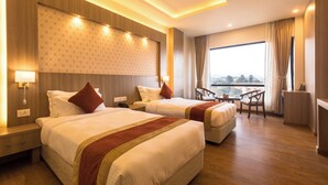 A hotel room with two beds, a view of the city, and a desk with a chair. - Hotel Landmark Kathmandu (Kathmandu)