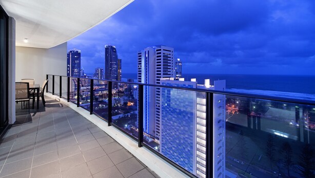 A balcony with a city view at dusk.