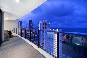 A balcony with a city view at dusk. - Sierra - Private Apartments (Broadbeach)